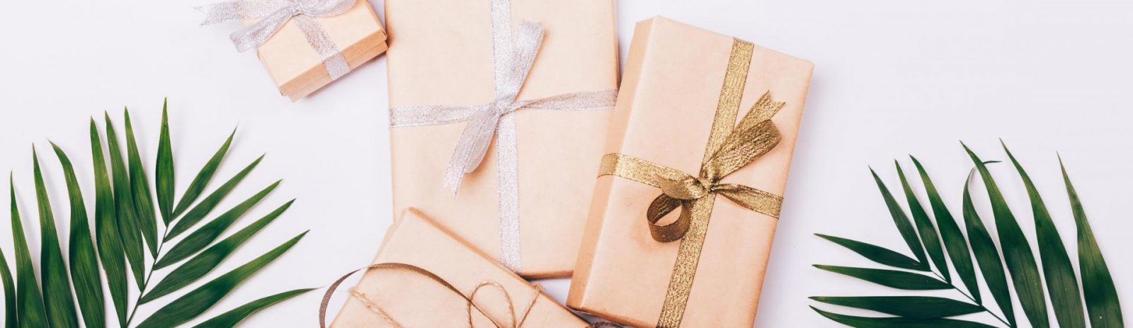 Paper wrapped gifts with palm leaves.