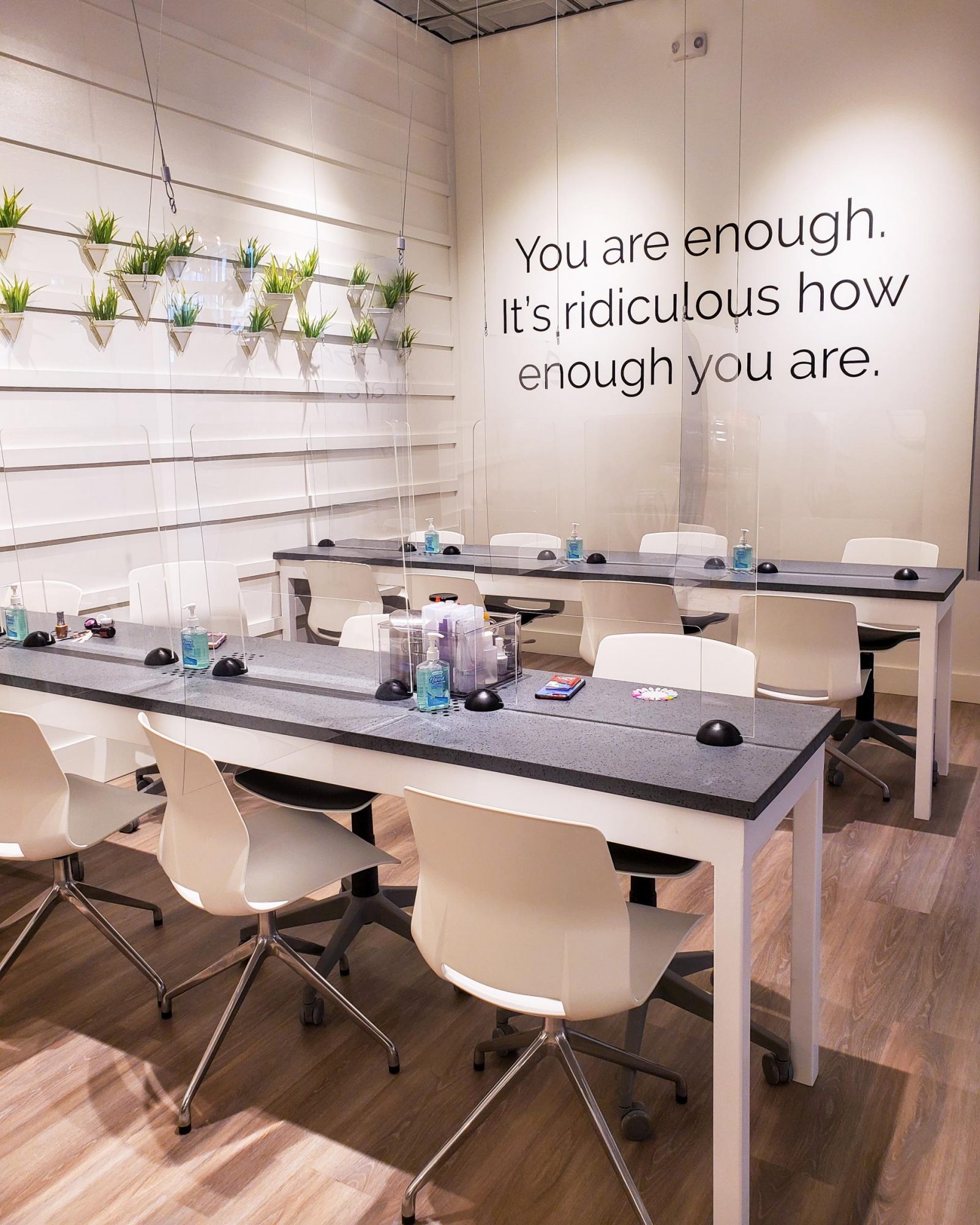 The manicure station with ample hand sanitizer and a sign that says "You are enough. It's ridiculous how enough you are."